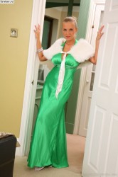 Сексуальная дама в зеленом платье и белых чулках задирает ноги