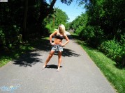 Эротичная блондинка в юбочке гуляет в парке