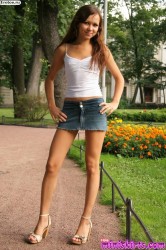 Молодая девушка в джинсовой юбке гуляет в парке